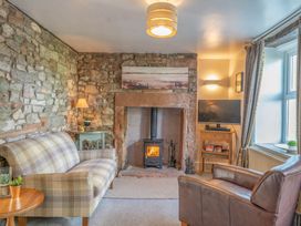 A living room featuring a fireplace and two seating areas at Cosy cottage near scenic walks and country pub in Penrith