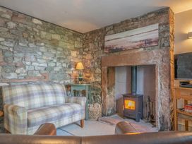 A living room with a sofa and fireplace at Cosy cottage near scenic walks and country pub in Penrith