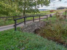 A bridge over a stream beside a path at Cosy cottage near scenic walks and country pub Penrith