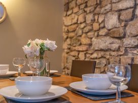 A dining table set with plates and glassware at Cosy cottage near scenic walks and country pub in Penrith