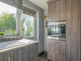 A kitchen with a window and oven at Cosy cottage near scenic walks and country pub in Penrith