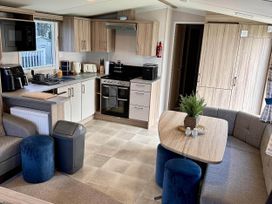 A kitchen with appliances and seating at R&R Coastal Retreats Cedars 63 Skegness
