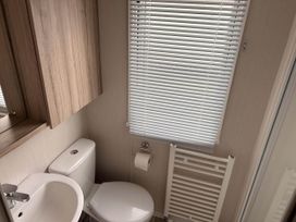 A bathroom with a toilet and sink at R&R Coastal Retreats Cedars 63 Skegness