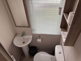 A bathroom with a sink and toilet at R&R Coastal Retreats Cedars 63 Skegness
