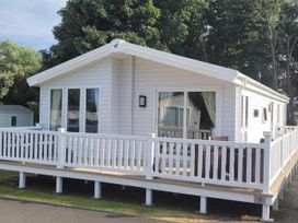 A mobile home with decking and outdoor furniture at Cayton Bay Lodge Parkdean Resorts in Scarborough