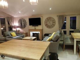 A living room with a sofa, television, and dining table at Cayton Bay Lodge Parkdean Resorts, Scarborough