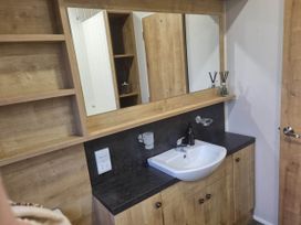 A bathroom with a sink and mirror at Cayton Bay Lodge Parkdean Resorts in Scarborough