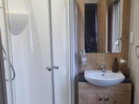 A bathroom with a shower and a washbasin at Cayton Bay Lodge Parkdean Resorts, Scarborough