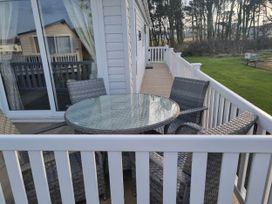 A deck with a table and chairs at Cayton Bay Lodge Parkdean Resorts in Scarborough