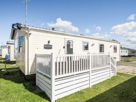 A mobile home with a deck and steps at Modena in Rhyl