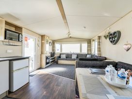 A living room with a sofa and table at Sleeps 8 Communal Spa Access Parking Rhyl
