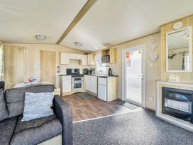 A kitchen with a sofa and appliances at Sleeps 8 Communal Spa Access Parking in Rhyl