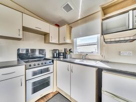 A kitchen with sink and oven at Sleeps 8 Communal Spa Access Parking in Rhyl