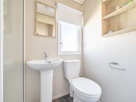 A bathroom with a sink and toilet at Sleeps 8 Communal Spa Access Parking Rhyl