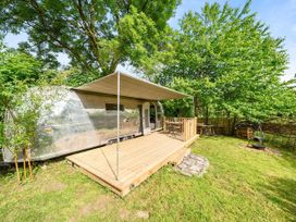 A trailer on a wooden deck surrounded by grass and trees at Sleeps 2 - Private Hot Tub - Fire Pit in St. Dogmaels near Cardigan