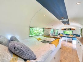 A living area with a bed and kitchenette in an accommodation at Sleeps 2 - Private Hot Tub - Fire Pit, St. Dogmaels near Cardigan