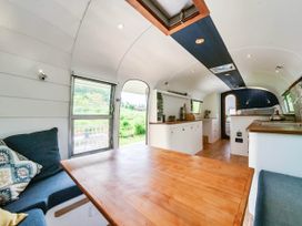 A living room with a table and couch at Sleeps 2 - Private Hot Tub - Fire Pit, St. Dogmaels near Cardigan