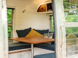 A dining area with a table and cushions at Sleeps 2 - Private Hot Tub - Fire Pit, St. Dogmaels near Cardigan