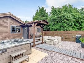 A garden with a wooden cabin and hot tub at Luxury 2 bedroom Lodge in rural lincolnshire