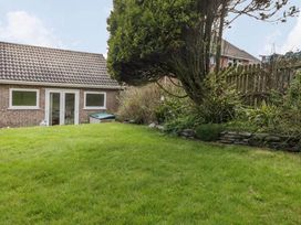 A garden with grass and a house in the background at Bungalow Sleeps 2 Parking in Newquay