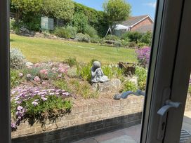 A garden with flowers and a statue at Bungalow Sleeps 2  Parking in Newquay