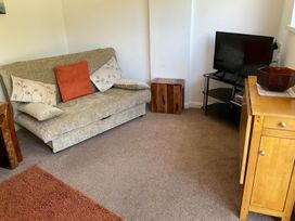 A living room with a sofa and television at Bungalow Sleeps 2 Parking in Newquay