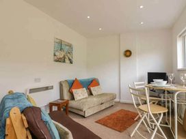 A living room with a sofa and dining area at Bungalow Sleeps 2 Parking in Newquay