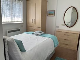 A bedroom with a bed and wardrobe at Bungalow Sleeps 2 Parking in Newquay