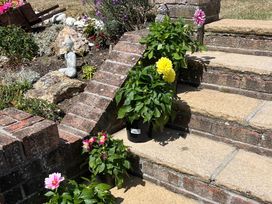 Steps with potted plants and a statue in the garden at Bungalow Sleeps 2 Parking Newquay