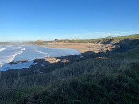 A beach with waves and cliffs at Bungalow Sleeps 2 Parking in Newquay