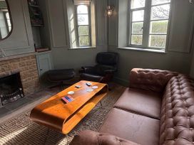 A living room with a sofa and chair at Cotswolds Castle Sleeps 8 with Enclosed Garden in Banbury