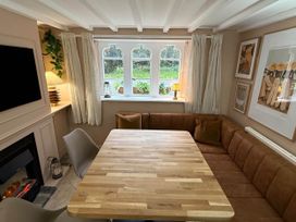 A dining room with a table and sofa at Cotswolds Castle Sleeps 8 with Enclosed Garden in Banbury