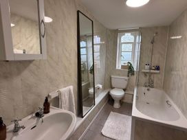 A bathroom with sink and bathtub at Cotswolds Castle Sleeps 8 with Enclosed Garden, Banbury