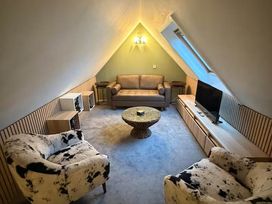 A sitting area with a sofa and television at 2 Bed Cottage Sleeps 4 Parking Wifi Darnick