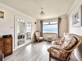 A living room with armchairs and a table at Porthleven Coastal Retreat with 5 Bedrooms in Porthleven