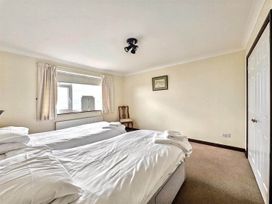 A bedroom with two beds and a chair at Porthleven Coastal Retreat with 5 Bedrooms, Porthleven