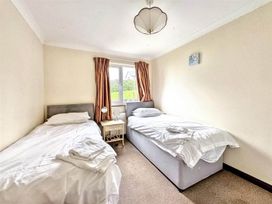 A bedroom with two beds and a nightstand at Porthleven Coastal Retreat with 5 Bedrooms, Porthleven