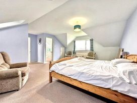 A bedroom with a bed and sofa at Porthleven Coastal Retreat with 5 Bedrooms, Porthleven