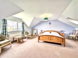 A bedroom with a bed and chairs at Porthleven Coastal Retreat with 5 Bedrooms, Porthleven