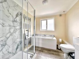 A bathroom with a shower, toilet, bathtub, and radiator at Porthleven Coastal Retreat with 5 Bedrooms in Porthleven
