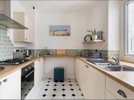 A kitchen with stove, sink, and counter at Beautiful Sea Front Cottage in Plymouth