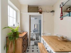 A kitchen with a dining table and cabinet at Beautiful Sea Front Cottage in Plymouth