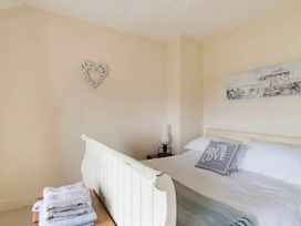 A bedroom with a bed and towels stacked in the Beautiful Sea Front Cottage in the Ocean City, Plymouth