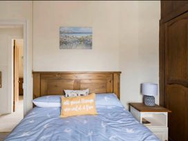 A bedroom with a bed, bedside table, and wardrobe at Beautiful Sea Front Cottage in Plymouth