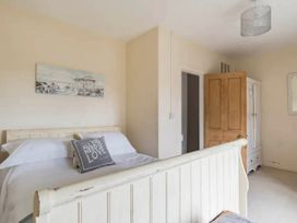 A bedroom with a bed and wardrobe at Beautiful Sea Front Cottage in Plymouth