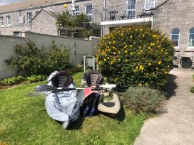 A garden with kayaks and paddles in front of a bush at Beautiful Sea Front Cottage in Plymouth