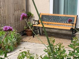 A bench next to a flowering plant at 2 Bed Sleeps 4 Parking Pets 10 min walk to Beach Falmouth