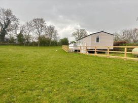 A caravan in a grassy area with trees at Caravan in Holcot Sleeps 6 Max 6 people Max 4 adults per booking Pet Friendly, Holcot near Moulton
