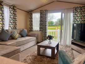 A living room with a sofa and coffee table at Caravan in Holcot Sleeps 6 Max 6 people Max 4 adults per booking Pet Friendly Holcot near Moulton