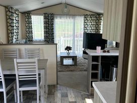 A living room with a dining table and chairs at Caravan in Holcot Sleeps 6 Max 6 people Max 4 adults per booking Pet Friendly in Holcot near Moulton